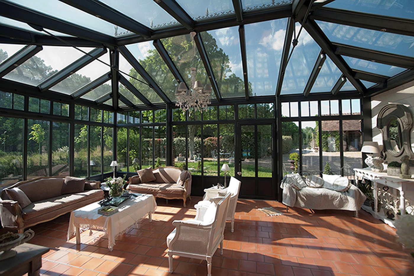 Véranda Verre Clair habitée, aménagée en salon lumineux ouvert sur le jardin